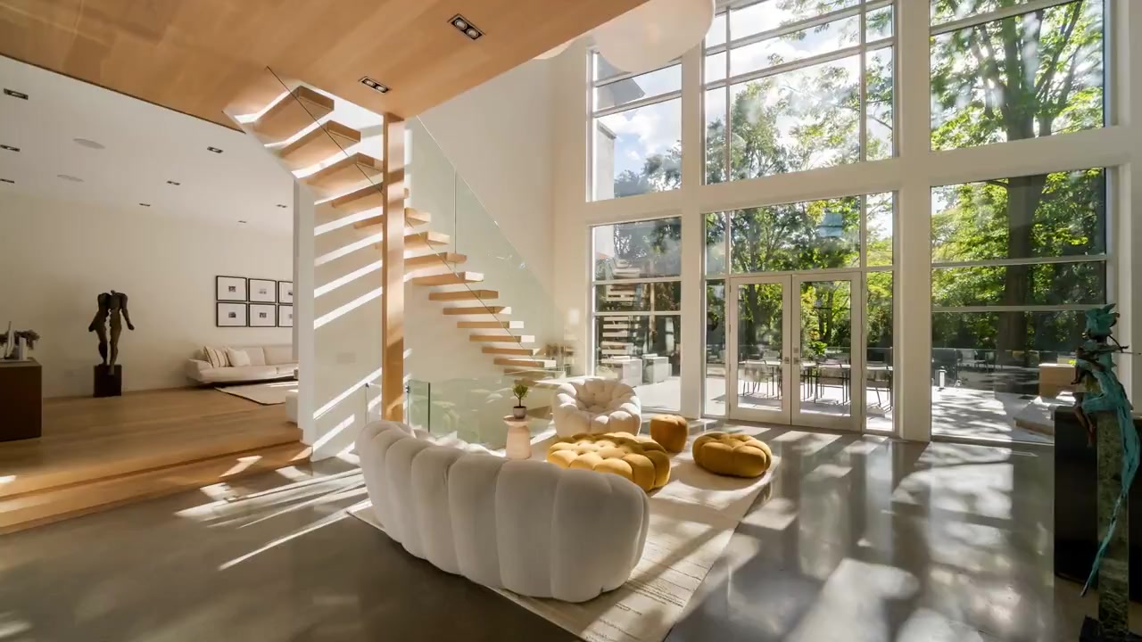 Sunlit living room with a floating staircase